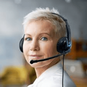 A female looking at the camera while wearing a black headset with blue accents. There is a microphone spanning from her left ear to her mouth.