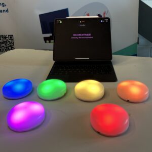6 different coloured Cosmoids arranged in front of an iPad which has the Cosmo app on it.