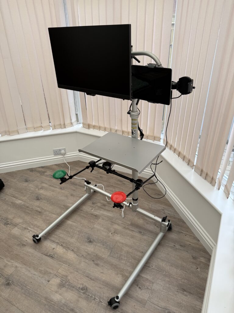 Rehadapt pentalock stand a Laptop tray, mounted is a 27" monitor with a Microsoft Surface Go and Mobile phone. connected to the Go is two quick access buttons for mouse and computer control.