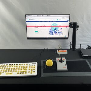 A computer with a Accuratus Monster 2 keyboard and Maxess Velcro mat and button mount holding a yellow button.