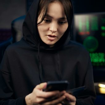 Young girl on her phone wearing a black hoodie